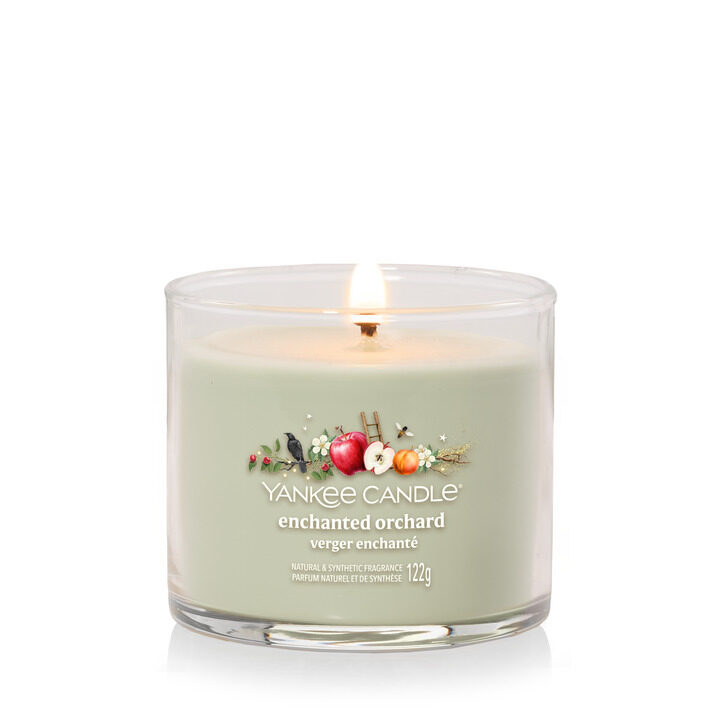 Yankee Candle Enchanted Orchard ljus, elegant glasbehållare, brinnande låga.