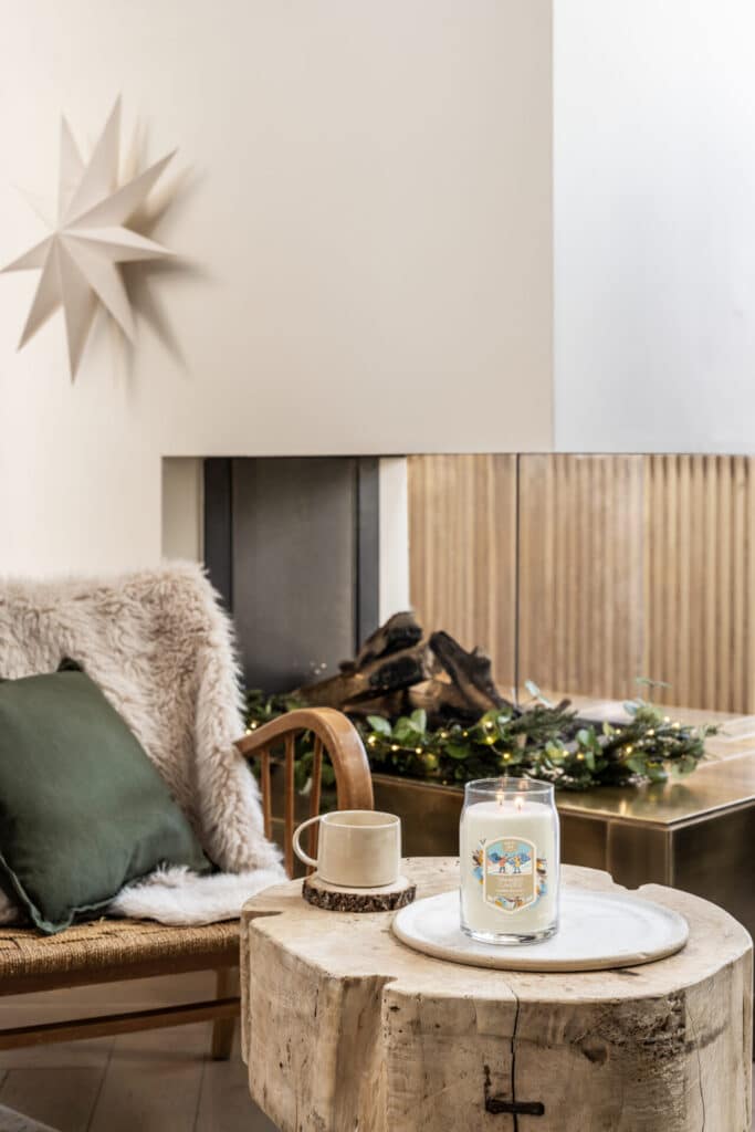 Mysig inredning med tänd ljuslykta och stjärndekoration i vardagsrum.