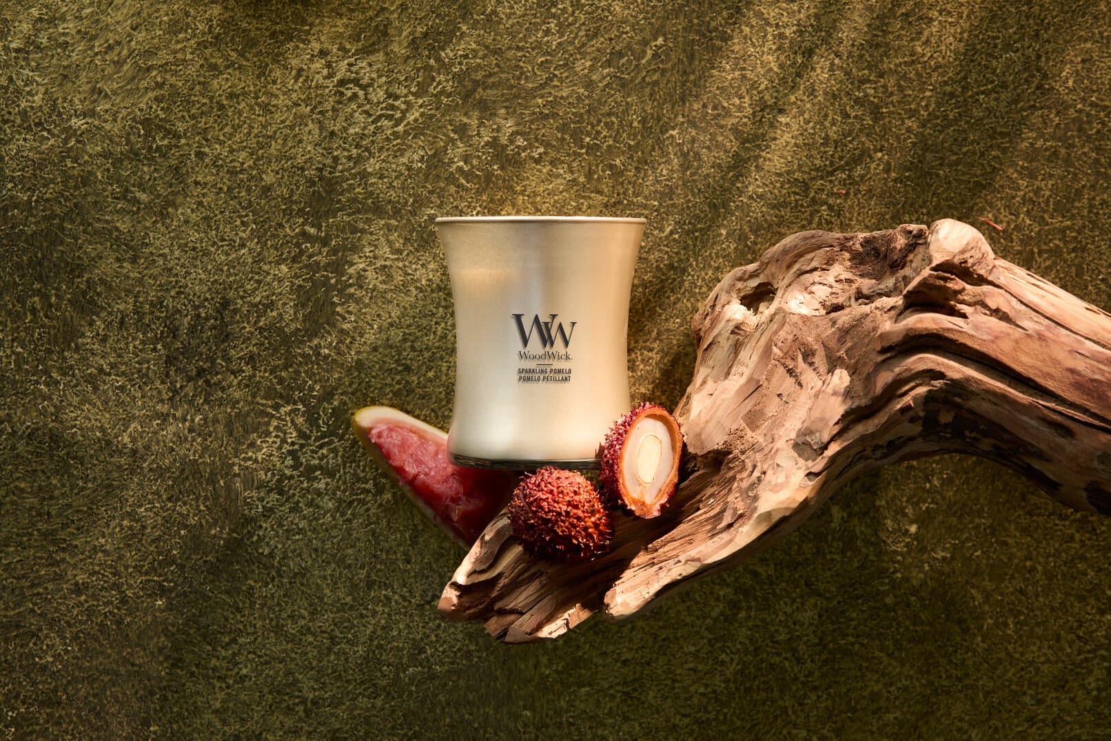 Lyxljus och exotisk frukt på träbakgrund.