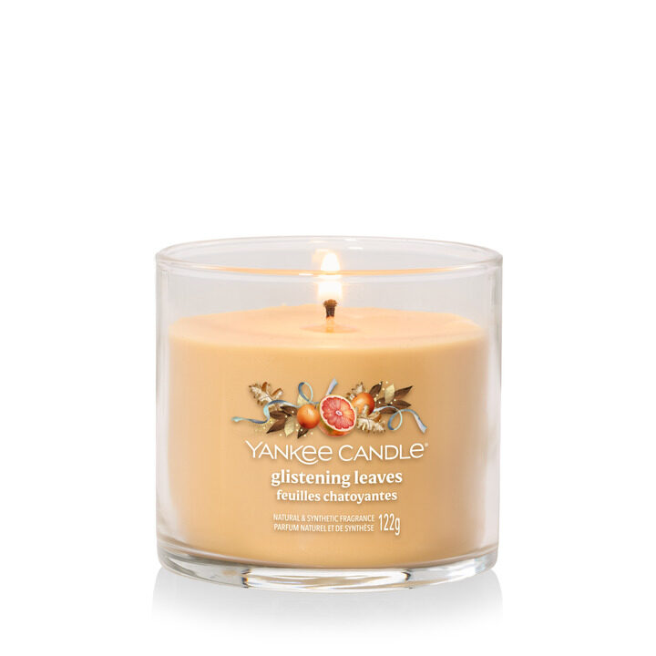 Scented candle in glass jar, labeled Glistening Leaves by Yankee Candle.