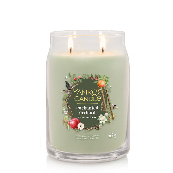 Grönt doftljus från Yankee Candle, Enchanted Orchard, med två brinnande vekar.