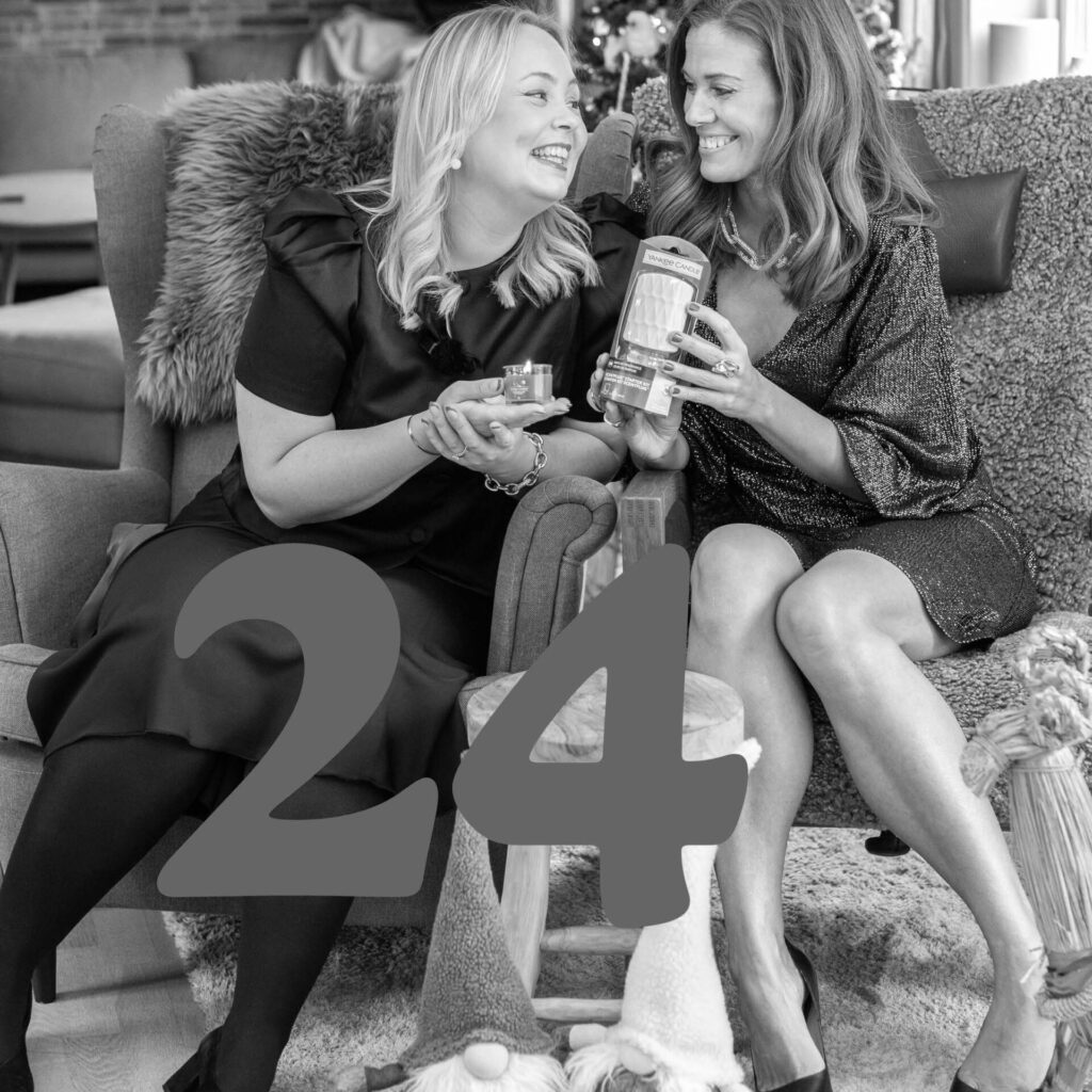 Två kvinnor firar jul med presenter och skratt i hemmamiljö.