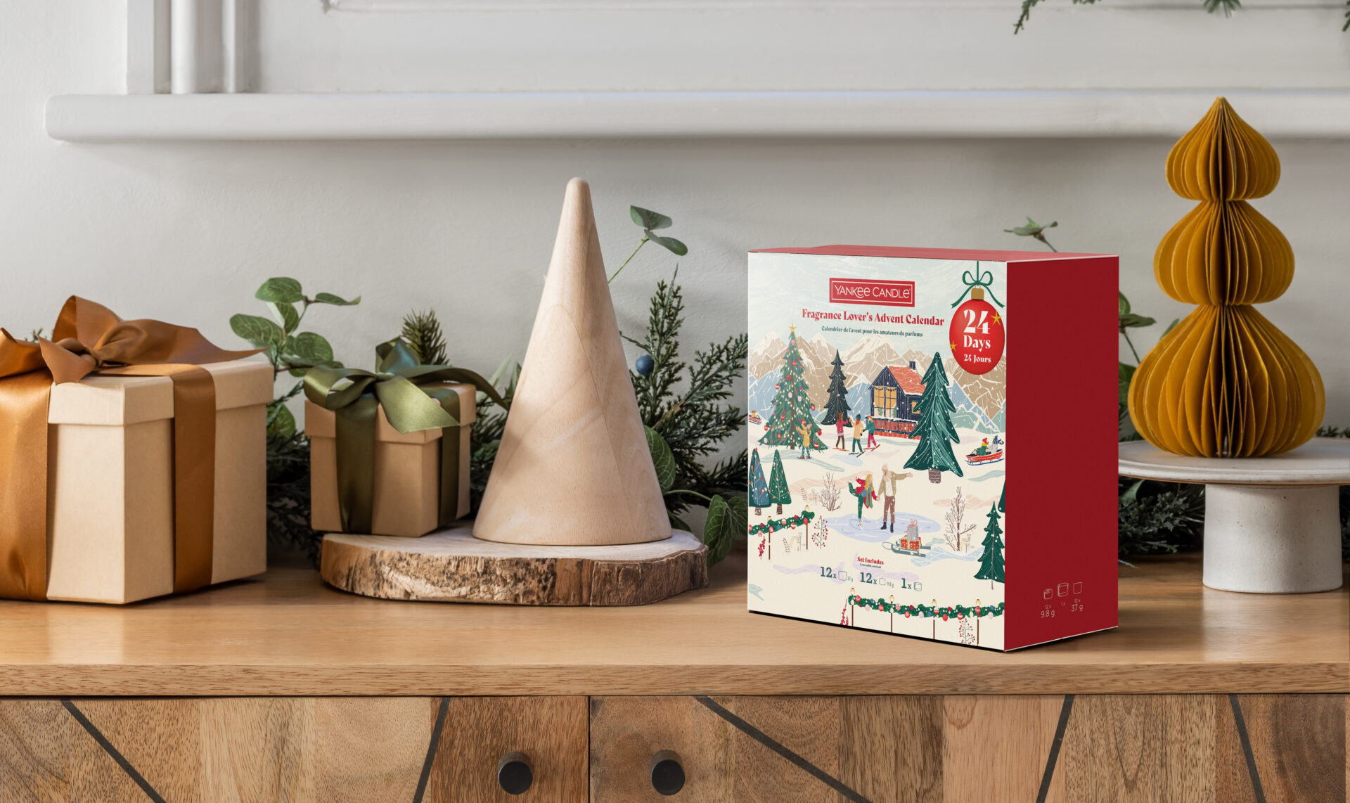 Yankee Candle adventskalender på juldekorerad hylla med presentpaket.
