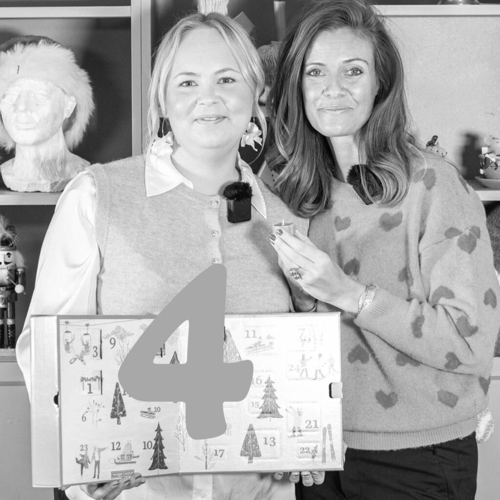 Två kvinnor med julkalender i svartvitt foto.