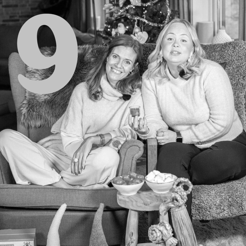 Två kvinnor sitter framför en julgran med ljus, nummer 9 i ett hörn.